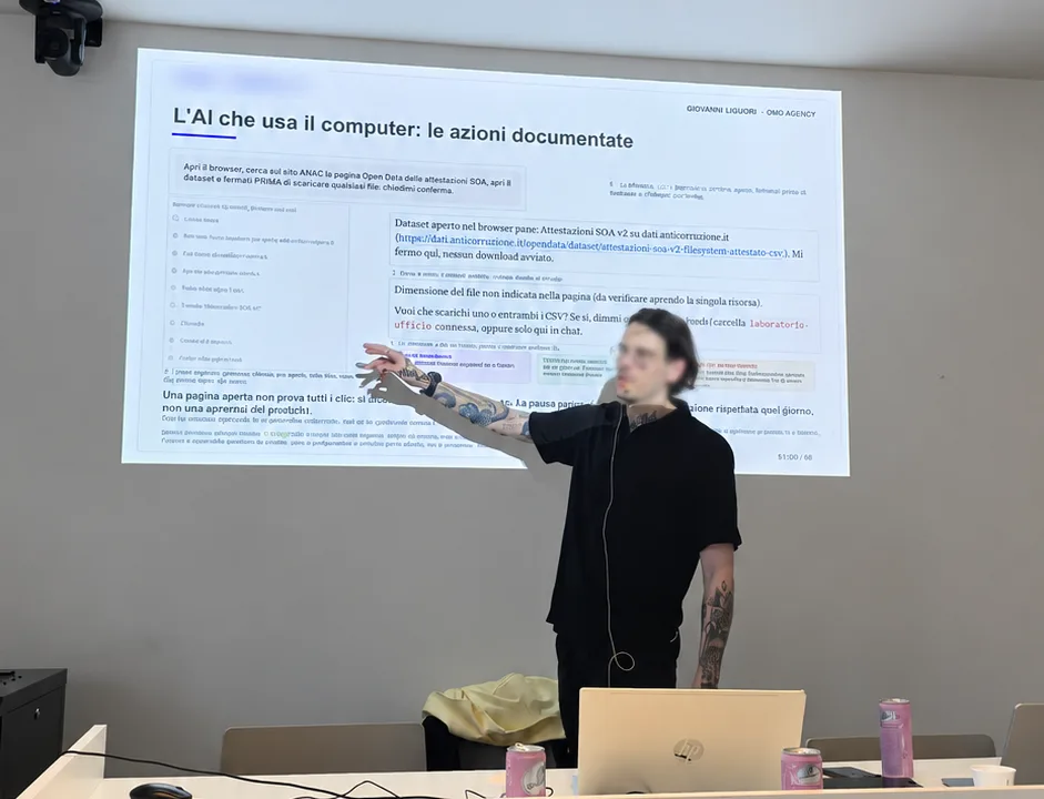 Giovanni Liguori in aula mostra alla slide un agente AI che usa il browser, con le azioni documentate passo per passo