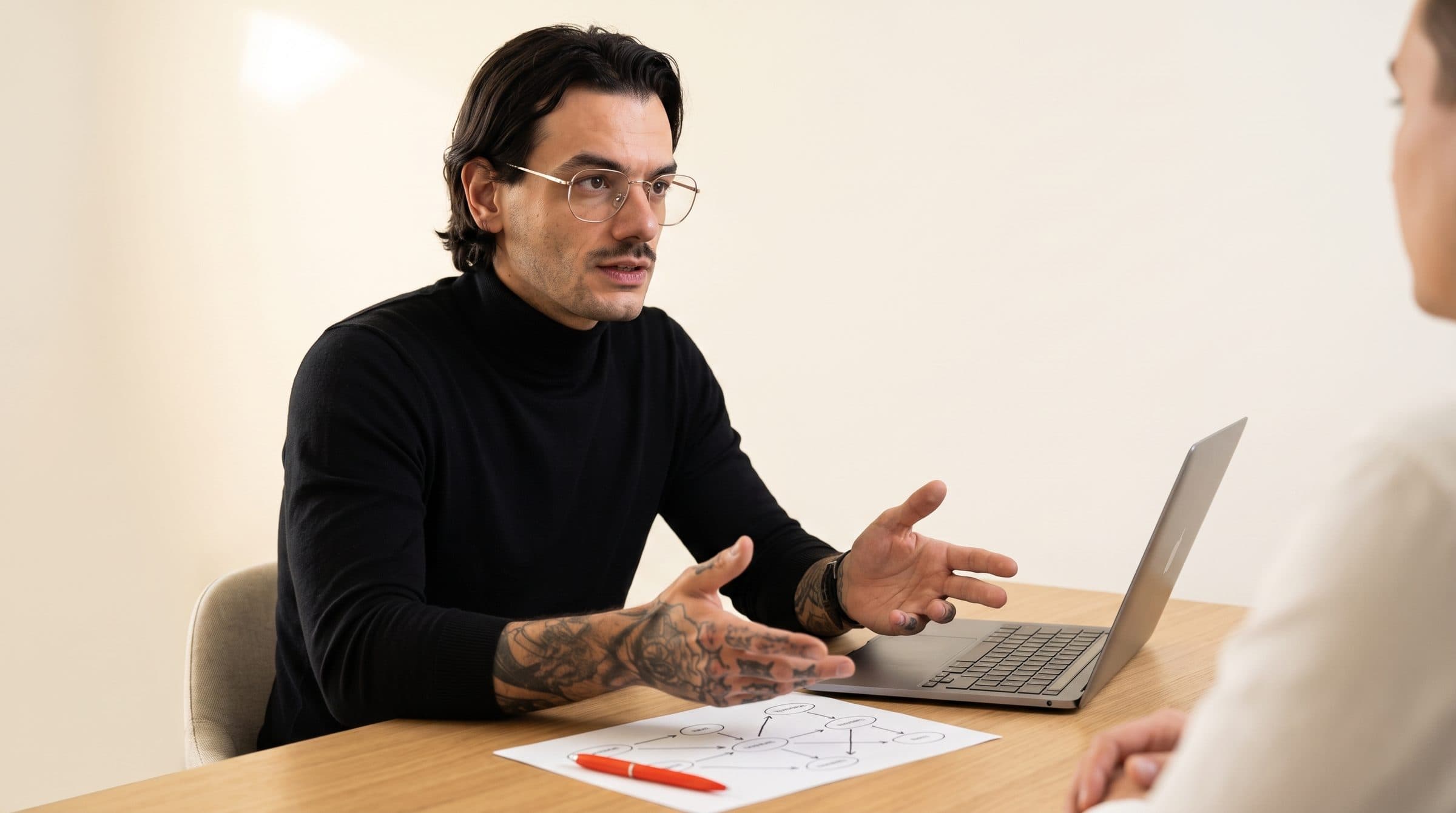 Giovanni Liguori durante una sessione di consulenza, al tavolo con un cliente mentre spiega il diagramma del processo.